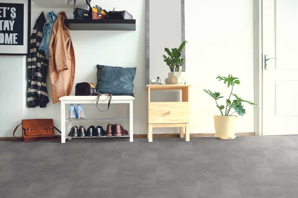 concrete look luxury vinyl tile in modern entryway with shoe rack